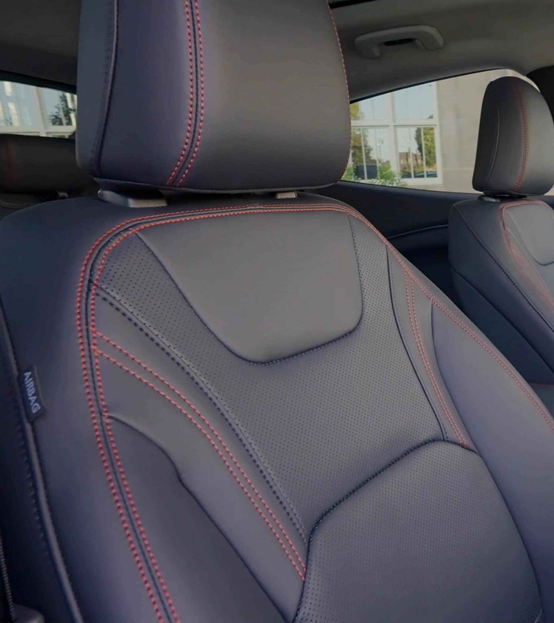 2025 Ford Mustang Mach-E® Premium model seats with red accent stitching and ActiveX® material